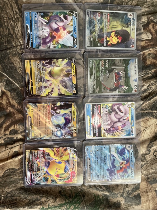 8 Holographic Pokemon Cards. 2 Ex, 2 V’s, 1 Vstar, 1 Vmax, And 2 Regular.